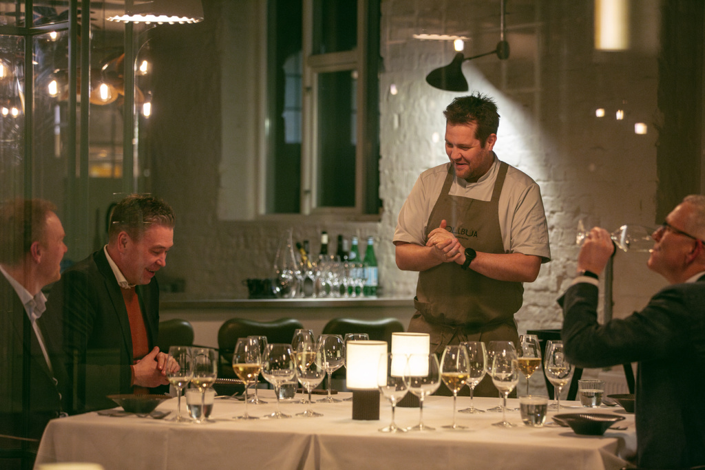 Chef Christopher Davidsen presenting food to guests at a private dining event in Tollbua Restaurant 