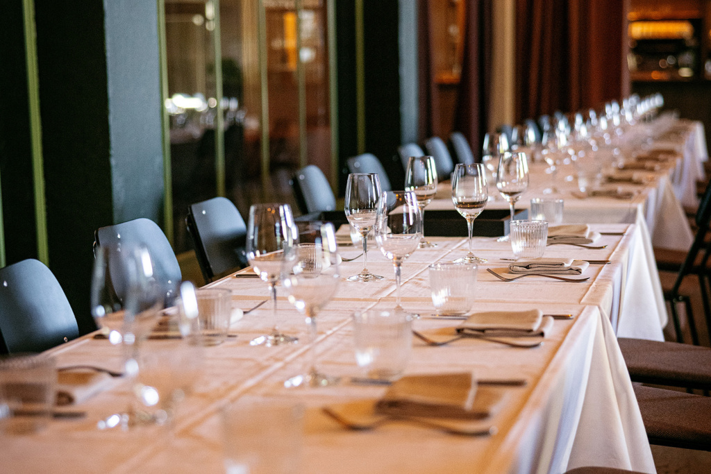 Long table set up for event with table cloth and wine glasses in Tollbua restaurant's South Wing